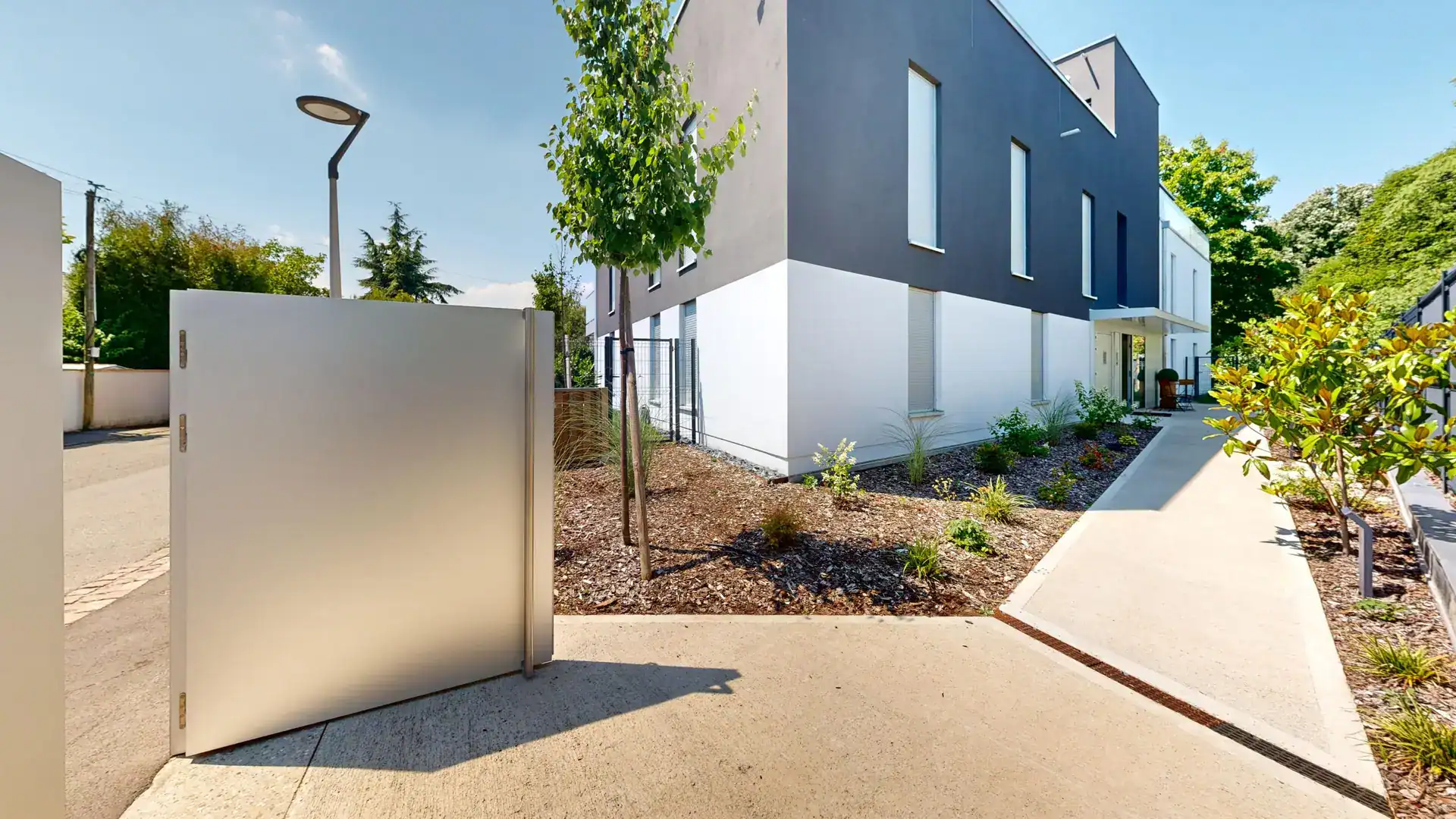 Résidence moderne à Colmar avec bâtiments contemporains et espaces verts, idéal pour projets immobil.