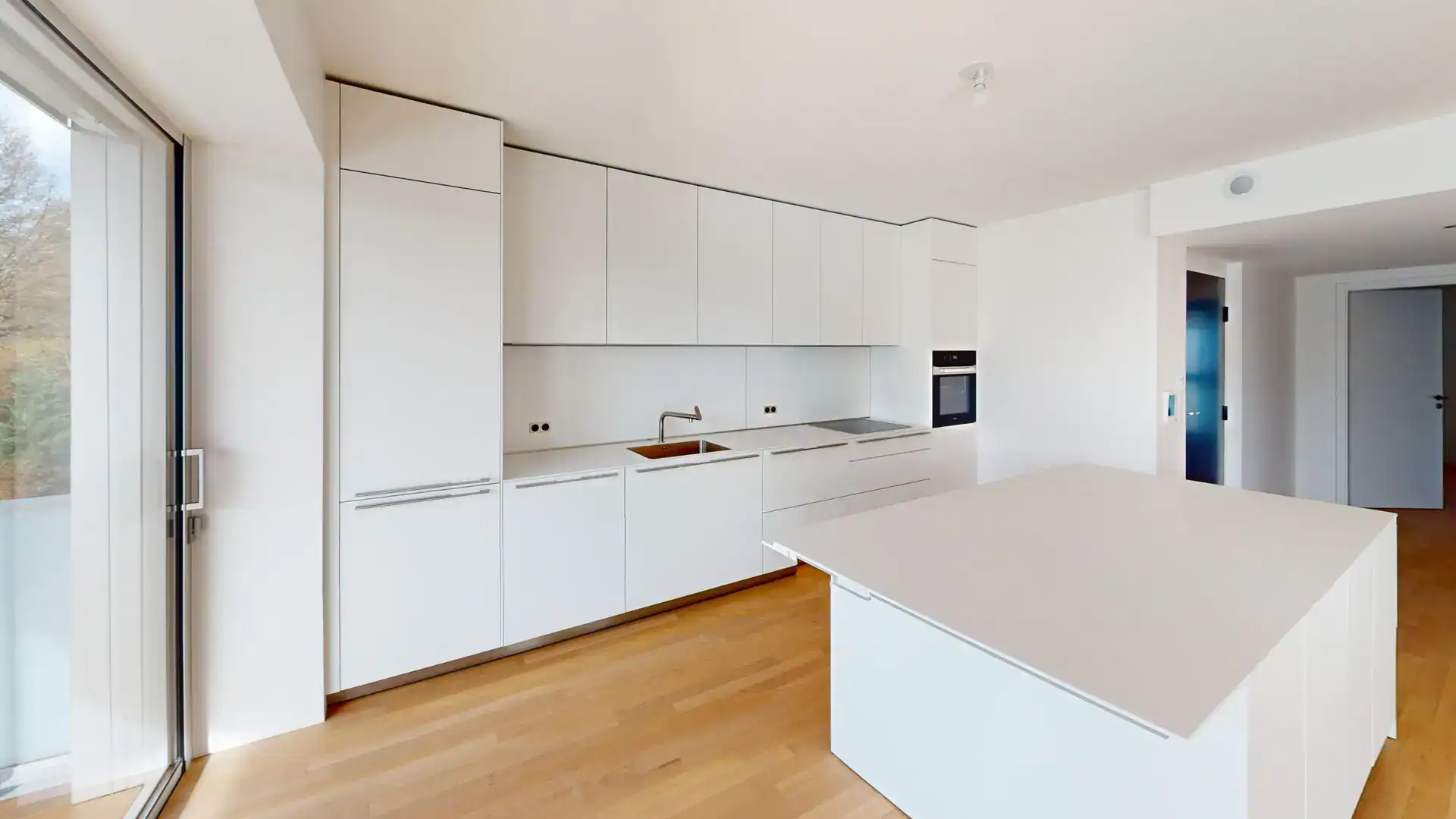 Cuisine contemporaine avec îlot central dans un appartement neuf à Colmar, Alsace.