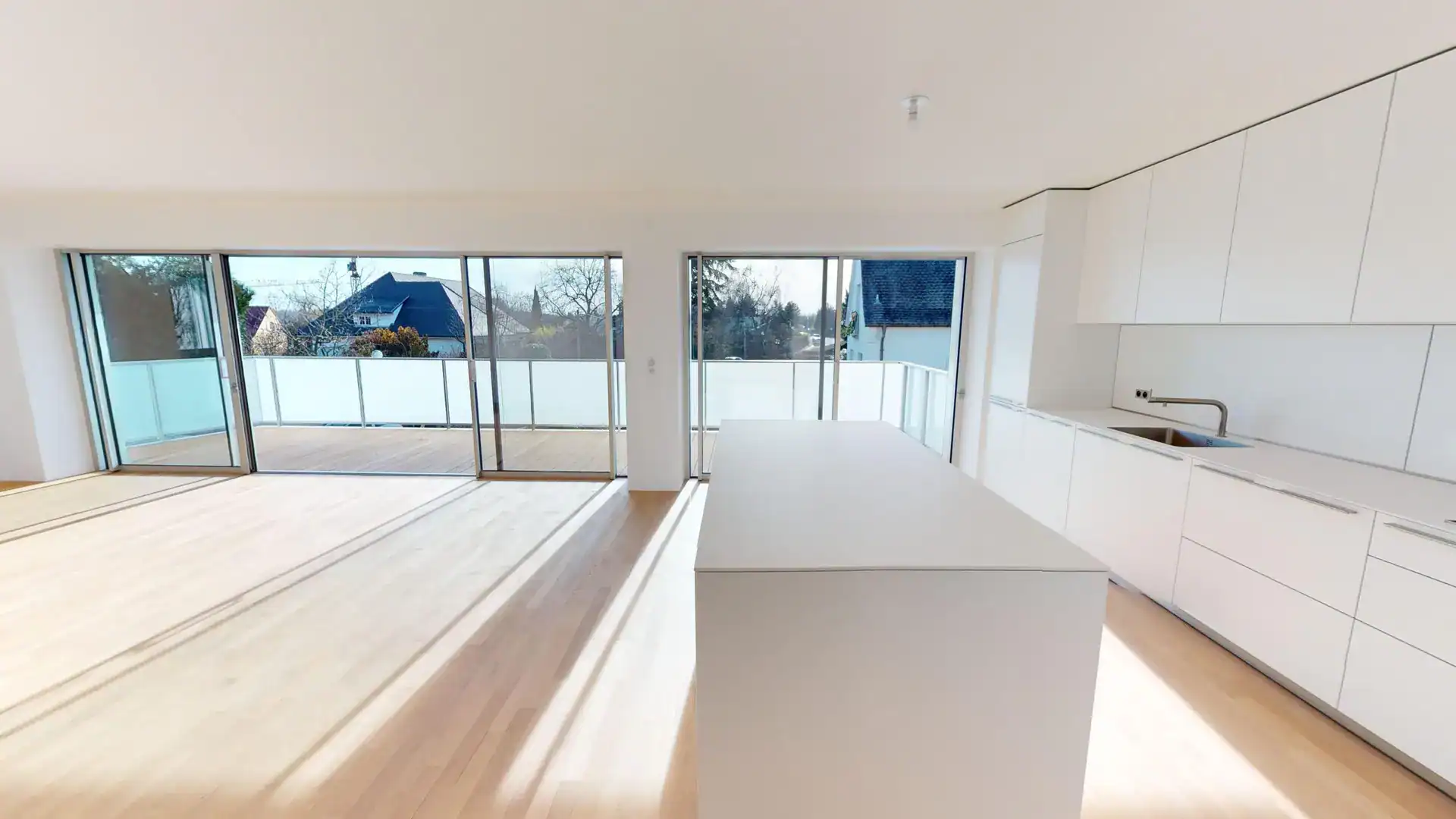 Cuisine moderne avec grand plan de travail blanc et fenêtres panoramiques à Colmar.
