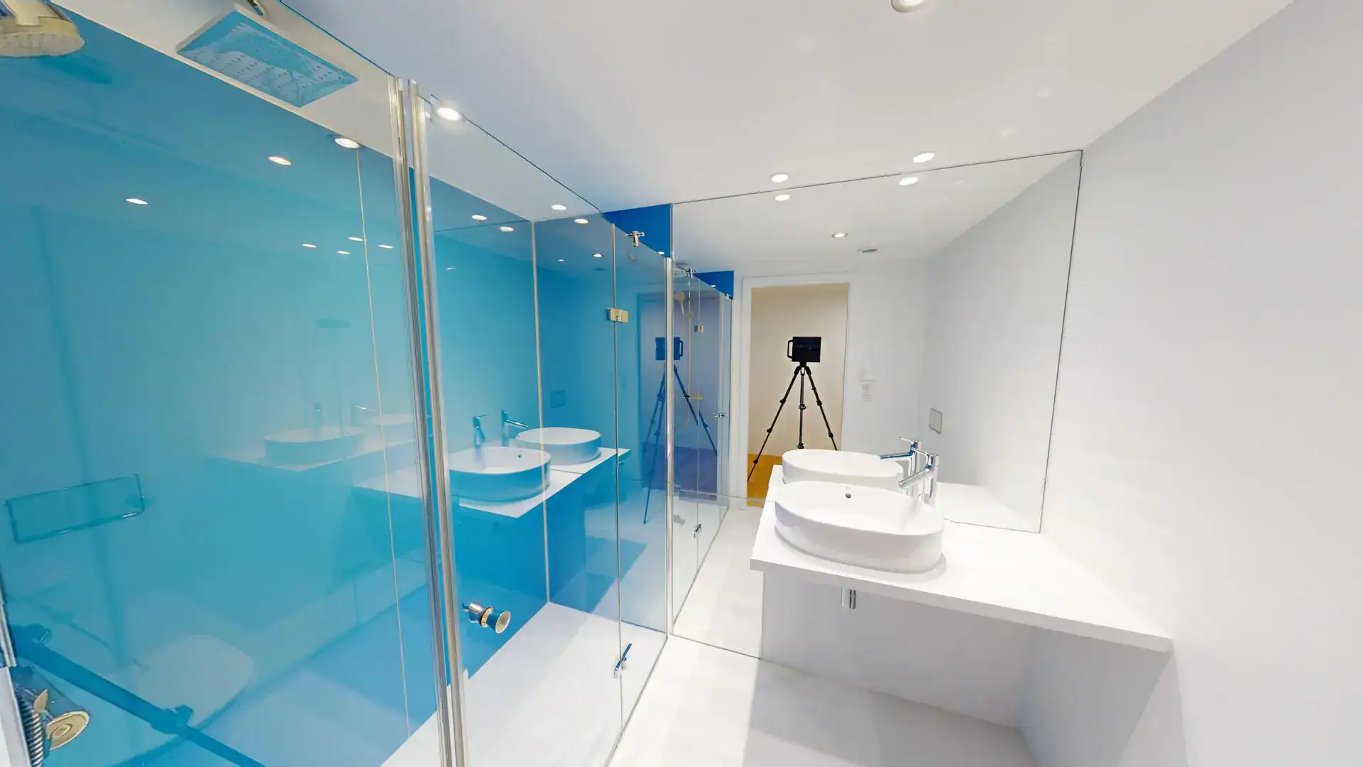Vasque blanche design dans salle de bain contemporaine avec miroir et douche en verre.