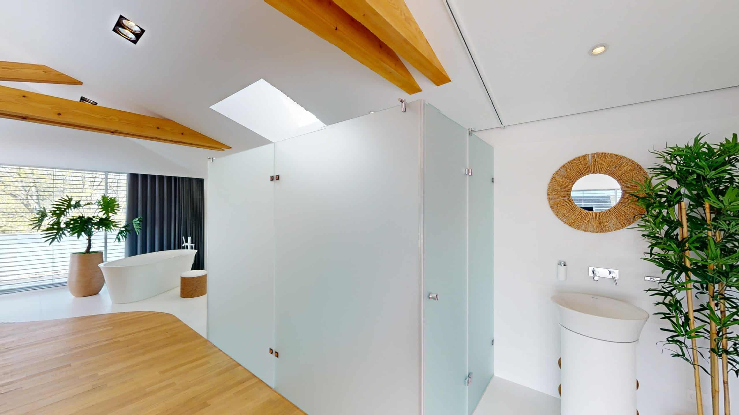 Photo d'une salle de bain contemporaine avec douche, miroir rond en rotin et plantes vertes.