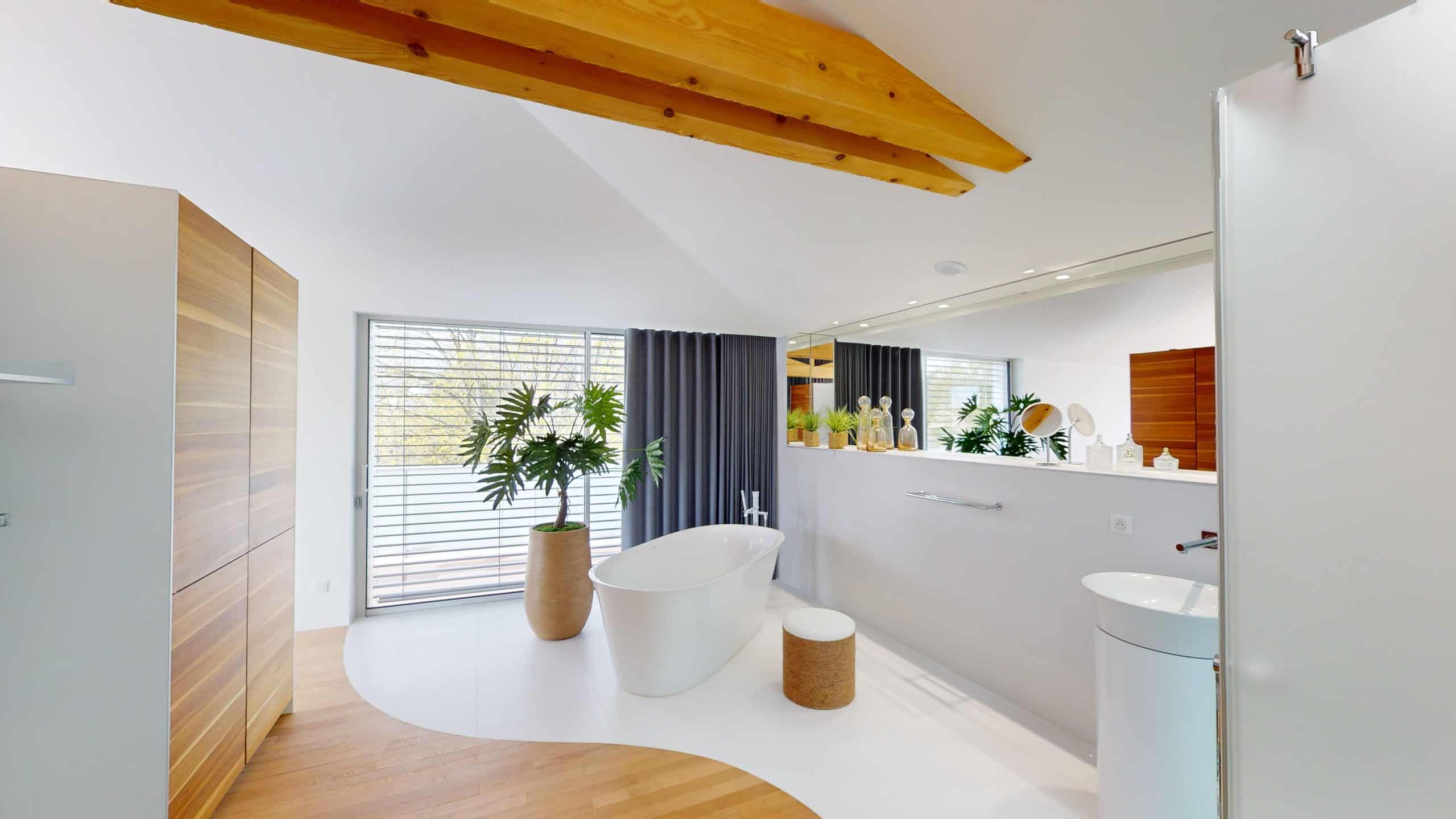 Salle de bain contemporaine avec baignoire autoportante, plantes et éclairage naturel.
