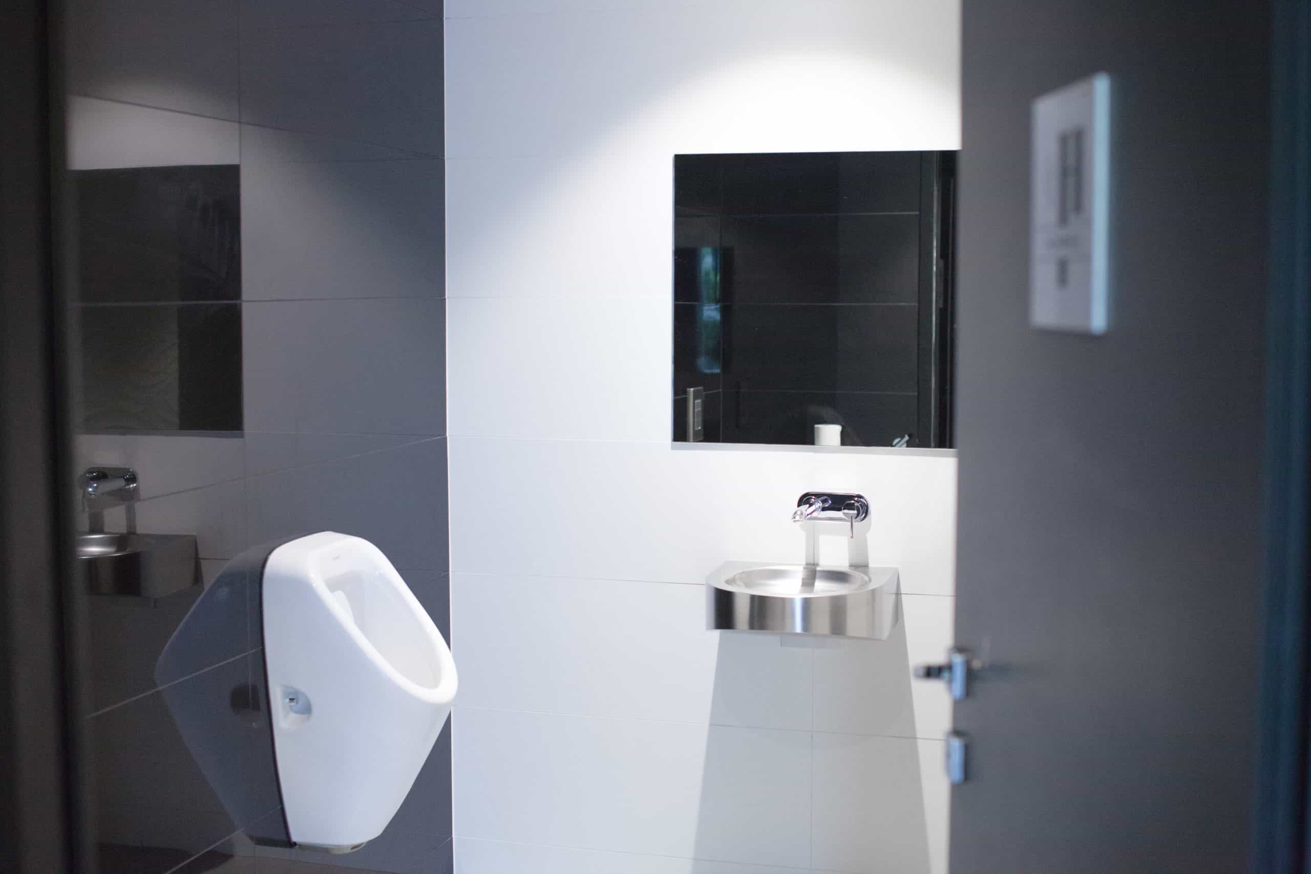 Toilette publique avec lavabo, espace propre et lumineux, idéal pour les bâtiments modernes.