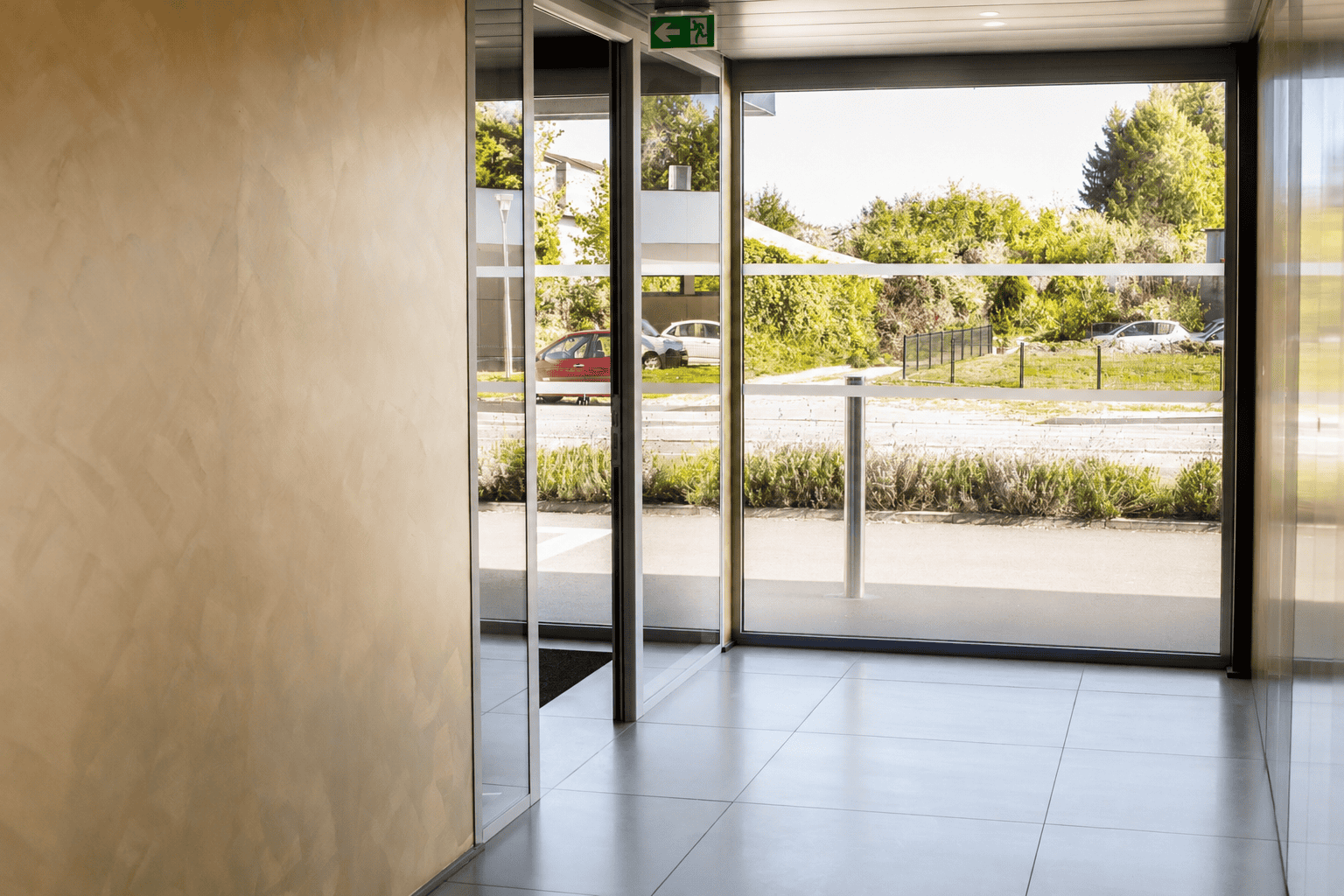 Bureau professionnel avec grandes fenêtres offrant une vue extérieure verdoyante à Colmar.